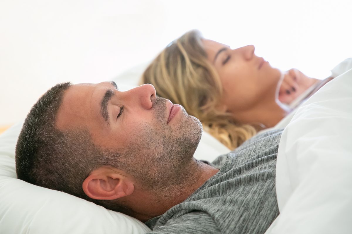 Couple sleeping peacefully together in bed