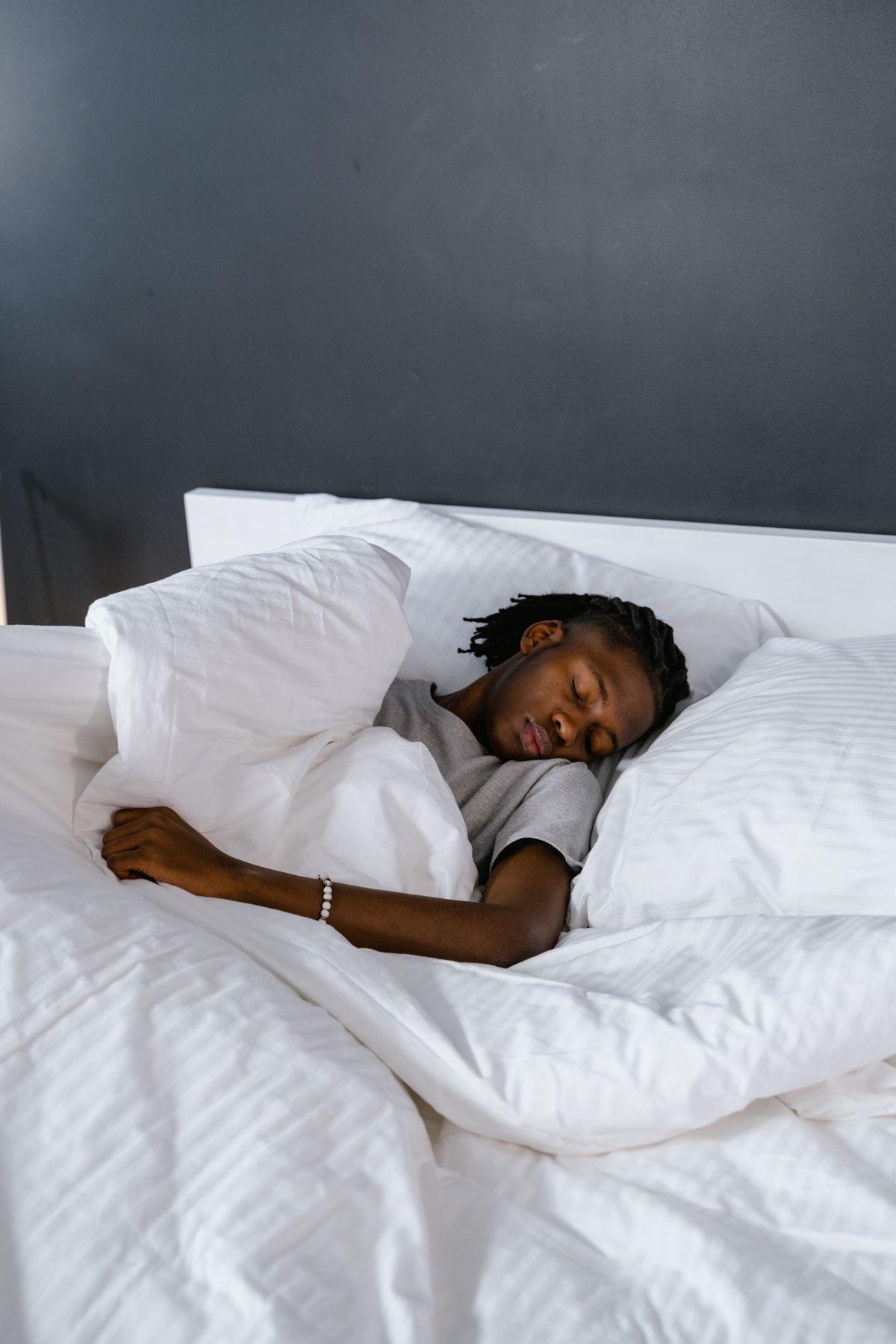 Adult sleeping quietly on a bed with white pillows